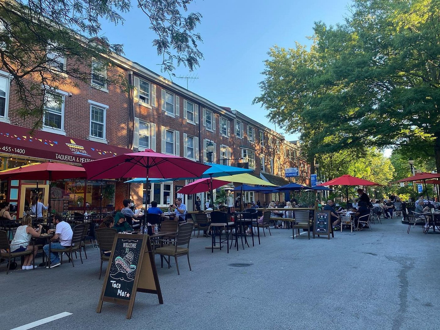 An open-air market in downtown West Chester, PA, with shoppers browsing vendor stalls